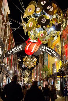 the rolling stones'christmas decorations are hanging from wires in an alleyway at night