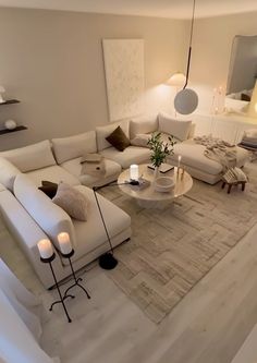 a living room filled with white furniture and candles