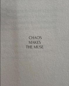 the words chaos makes the muse written in black ink on a white sheet of paper