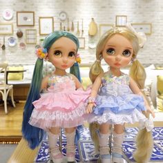 two dolls sitting on top of a table