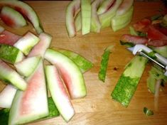 sliced up watermelon and cucumber on a cutting board with a knife