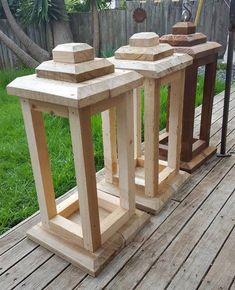 three wooden planters sitting on top of a wooden deck next to a green yard