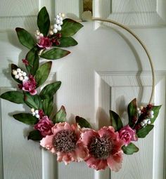 a wreath with pink flowers and green leaves