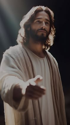 a man with long hair wearing a white robe and holding his hands out to the side