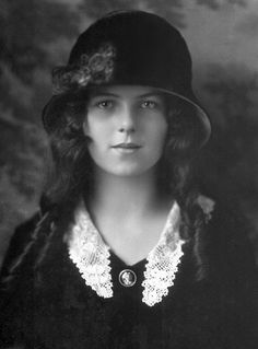 an old black and white photo of a woman wearing a hat