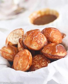 some kind of food that is in a paper bag on a white tablecloth with sauce