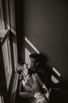 a man and woman sitting next to each other near a window