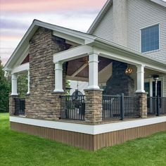 a house with stone pillars and columns on the front porch