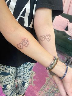 two people with matching tattoos on their arms