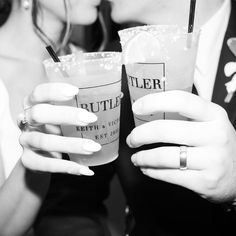 black and white photograph of two people holding drinks