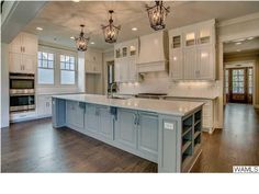 a large kitchen with an island in the middle and lots of cabinets on both sides