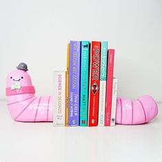 a pink bookend sitting next to a stack of books