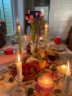 a dinner table with candles and food on it