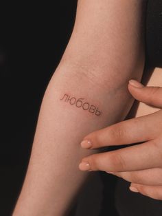 a woman's arm with the word booboom tattooed on her left arm