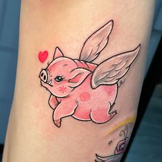 a small pig tattoo on the leg with wings and hearts around it's eyes