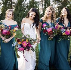 a group of women standing next to each other with bouquets in their hands and smiling at the camera