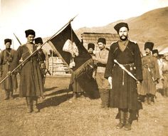 a group of men standing next to each other holding flags