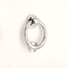 a pair of silver rings on a white wall with one ring attached to the other