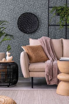 a living room filled with furniture next to a wall covered in plants and potted plants