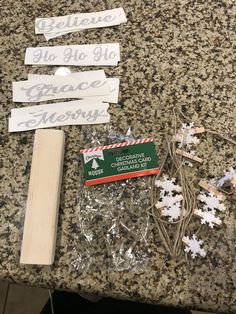 some pieces of wood are sitting on the counter next to snowflakes and christmas decorations