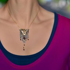 a woman wearing a necklace with an ornate design on the front and back of her neck