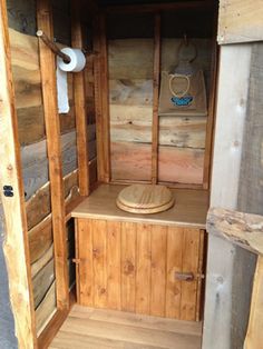 the inside of an outhouse with wooden walls and wood flooring, including a toilet