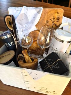 a wooden box filled with wine glasses and other items sitting on top of a table