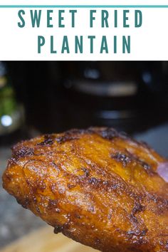 a piece of fried plantain is being held up by a person's hand