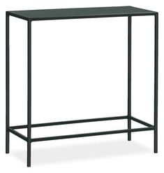 a black metal table with a shelf on the bottom and one leg up against it