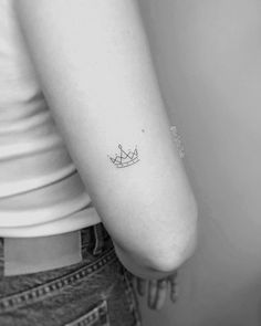 a woman's arm with a small boat tattoo on the back of her left arm