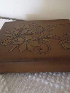 an ornate wooden box sitting on top of a bed