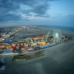 an aerial view of the amusement park and beach area at night, with ferris wheel in foreground