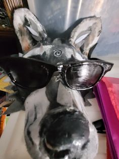 a sculpture of a dog with sunglasses on it's head and wearing shades to protect his eyes