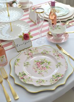 the table is set with pink and white china