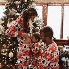 a woman and two men in matching christmas pajamas