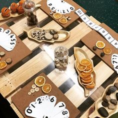 a board game with oranges and coins on it, as well as some sort of clock