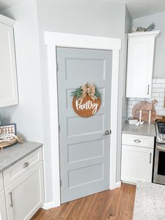 a kitchen with white cabinets and gray doors that say family on the front door,