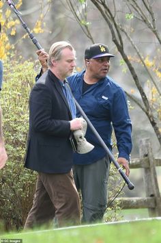 two men are holding golf clubs in their hands