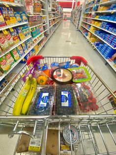 a shopping cart filled with groceries in a grocery store aisle next to shelves full of milk, yogurt, and other items