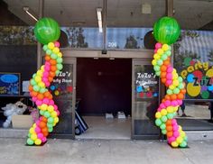 an entrance decorated with balloons in the shape of a number one and two green balls