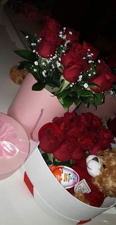 a teddy bear in a pink box with roses