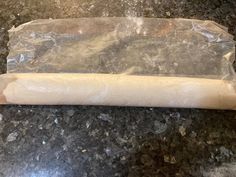 a piece of bread wrapped in plastic sitting on top of a counter