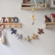 there are wooden letters that spell out the word leo and an airplane hanging from some shelves