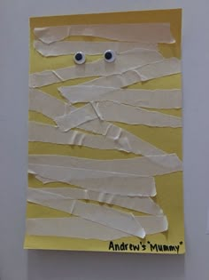 a piece of paper with googly eyes and strips of white paper taped to it