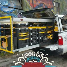 the back end of a white pickup truck with tool boxes in it's bed