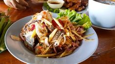 two plates filled with food sitting on top of a wooden table next to a cup