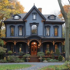 a large blue house with lots of windows on it's front porch and steps leading up to the entrance