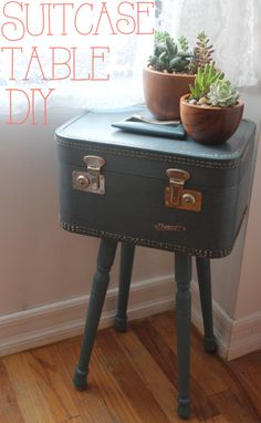 an old suitcase is turned into a side table with succulents on top