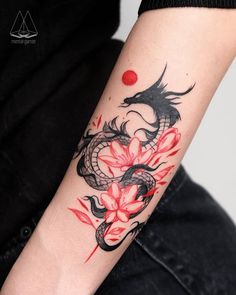 a woman's arm with a dragon and flowers tattoo on the left side of her arm