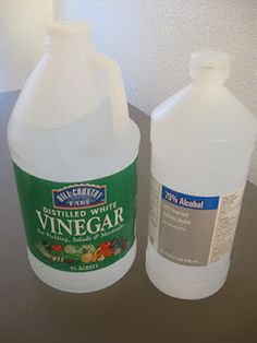 two bottles of vinegar sitting on top of a table